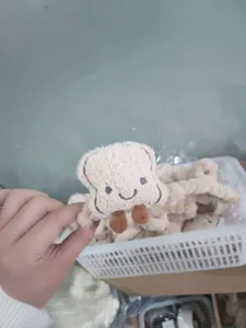 Gros plan d'une jolie pince à cheveux en peluche en forme de toast tenue par une main
