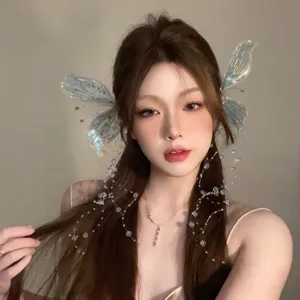 Détail de barrettes ailes de papillon irisées avec des fils de perles de cristal.