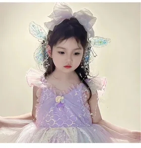 Gros plan de pinces à cheveux ailes de papillon en cristal avec pompons perlés pour fille.