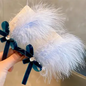 Détail en gros plan d'une barrette en plumes bleues avec nœud en velours et cristaux.