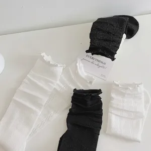 Dettaglio calzini arricciati stile JK in bianco e nero con motivi a maglia testurizzati