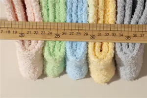Vista detallada de calcetines de vellón de coral macaron con una regla de madera para escala