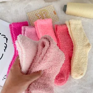 Detailed macro view of soft coral fleece socks in vibrant candy pink and cream colors