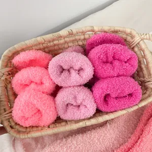 Soft and cozy coral fleece sleep socks in assorted pink shades displayed in a woven basket