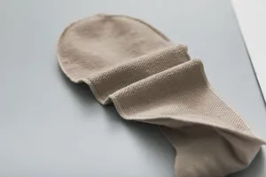 Detail eines nahtlosen beigen Söckchens mit weicher Textur und rutschfester Kante