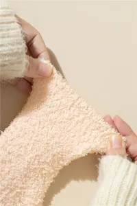 Primer plano de calcetines elásticos de forro polar coral rosa con textura suave y elasticidad.