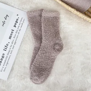 Detailed view of soft, cozy coral fleece sleep socks in dusty rose color on a plush white rug