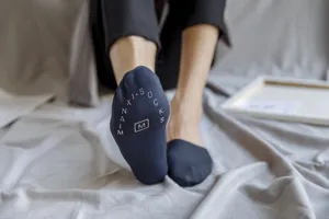 Nahaufnahme von dunkelblauen rutschfesten Herrensocken mit dem Logo auf der Sohle