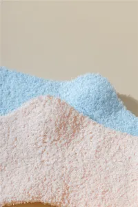 Primer plano de suaves calcetines de dormir en forro polar coral rosa y azul pastel.