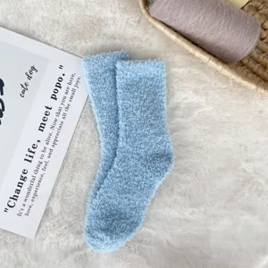 Macro view of light blue coral fleece socks with soft fuzzy texture on white fur background
