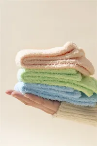 Primer plano de calcetines suaves de forro polar coral de colores macaron sobre una mano
