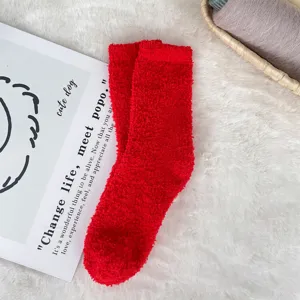 Close-up macro view of red coral fleece plush socks with soft texture for cozy home wear