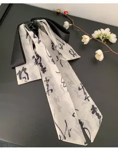 Détail de l'impression calligraphique à l'encre sur le ruban blanc de la pince à cheveux