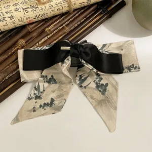 Détail d'une pince à cheveux de style chinois avec nœud et rubans à l'encre.
