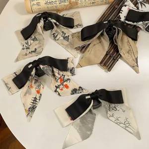 Vue détaillée des pinces à cheveux de style chinois avec nœuds à motif lavis d'encre.
