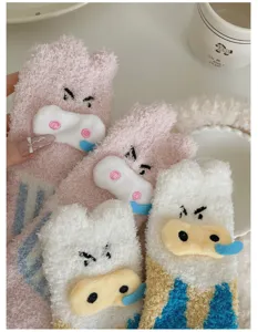 Makro-Detail des weichen Korallenvlies-Stoffs und der süßen Schweinchen-Gesichter auf Socken