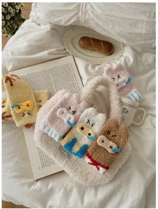 Gemütliche Winter-Socken aus Korallenvlies mit Schweinemotiv und Plüschtasche auf dem Bett