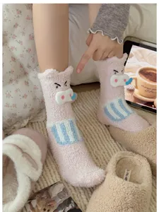 Nahaufnahme von rosa flauschigen Korallenvlies-Schlafsocken mit süßem Schweinedesign