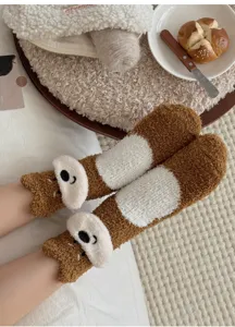 Gezellige bruine koraalvlies sokken met puppyontwerp aan de voeten in slaapkamer