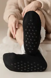 Nahaufnahme schwarzer rutschfester Socken mit Noppen und warmem Fleecefutter