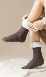 Detail der dicken, mit Fleece gefütterten Thermosocken an den Füßen auf einem Teppich