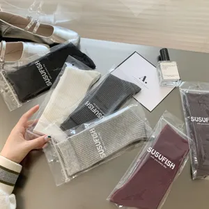 Detail view of multi-color ribbed calf socks with individual branded packaging