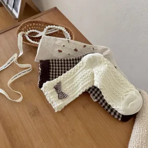 Detailed view of stylish Japanese-style socks with bow, floral and plaid patterns.
