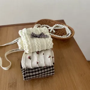 Close-up of three pairs of Japanese style winter socks with bow and floral patterns