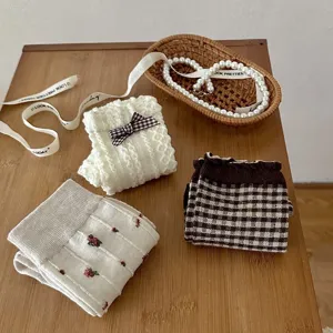 Details of Japanese style socks with bow, floral embroidery, and checkered patterns.