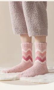 Dettaglio di calzini spessi in pile corallo rosa con motivo a zigzag per l'inverno.