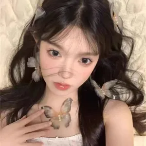 Gros plan de délicates pinces à cheveux papillon en cristal avec perles sur un mannequin.