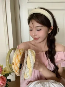 Asian model showcasing a collection of yellow and cream wide-brimmed fashion headbands