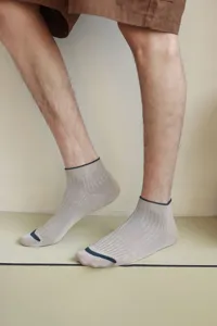 Detailed view of beige men's ribbed ankle socks with stylish navy blue trim accents