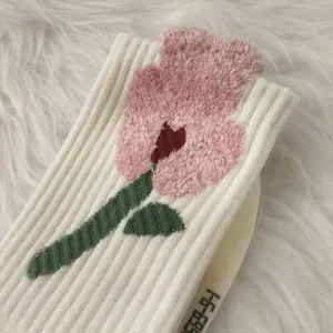 Close-up detail of cozy winter mid-calf sock with plush pink floral jacquard pattern