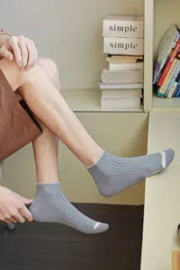 Detail of comfortable grey ribbed men's low cut socks worn in a lifestyle setting