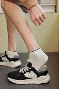 Detailed close-up view of men's cream-colored ribbed crew socks with a subtle black rim
