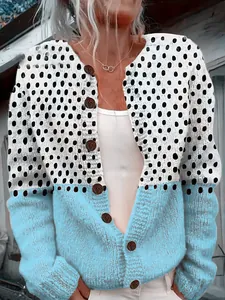 Detailed view of women's loose knit cardigan with white and blue polka dot design