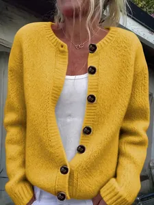 Close-up of women's loose mustard yellow knit cardigan with large dark buttons