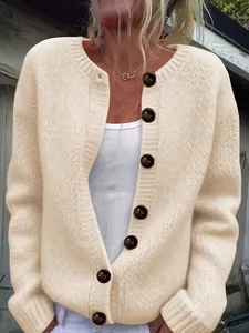 Detailed view of a cream-colored loose-knit cardigan featuring large decorative buttons.