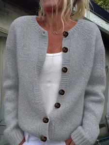 Close-up of a women's grey loose knit cardigan featuring large decorative brown buttons