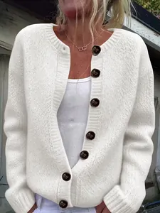 Close-up detail of a white loose knit women cardigan featuring stylish large contrast buttons