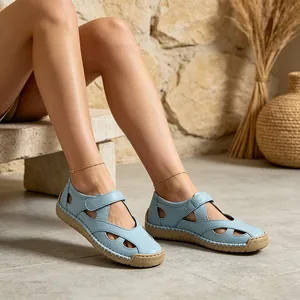 Detailed macro shot of light blue hollow leather sandals for women with Velcro straps