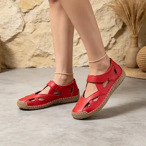 Close-up detail of red leather hollow-out casual sandals with white hand-stitching for women