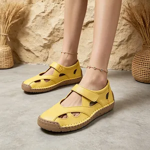 Close-up view of bright yellow leather hollowed-out sandals featuring hook and loop strap