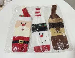 Detailed view of three knitted Christmas wine bottle covers in plastic packaging