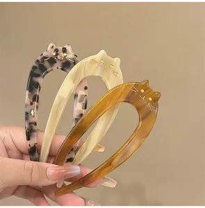 Close-up detail of cute cat-shaped acetate U-shaped hair forks in three trendy patterns