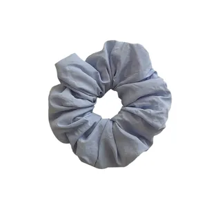 Elegant light blue oversized scrunchie hair tie with soft pleated fabric texture
