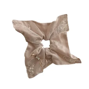 Elegant champagne mesh scarf scrunchie with delicate pearls and rhinestone bow