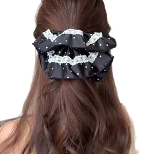 Large black and white polka dot lace scrunchie with elegant ruffle skirt design