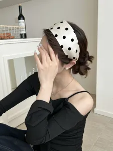 Serre-tête large élégant au fini perlé avec gros pois noirs sur profil de mannequin